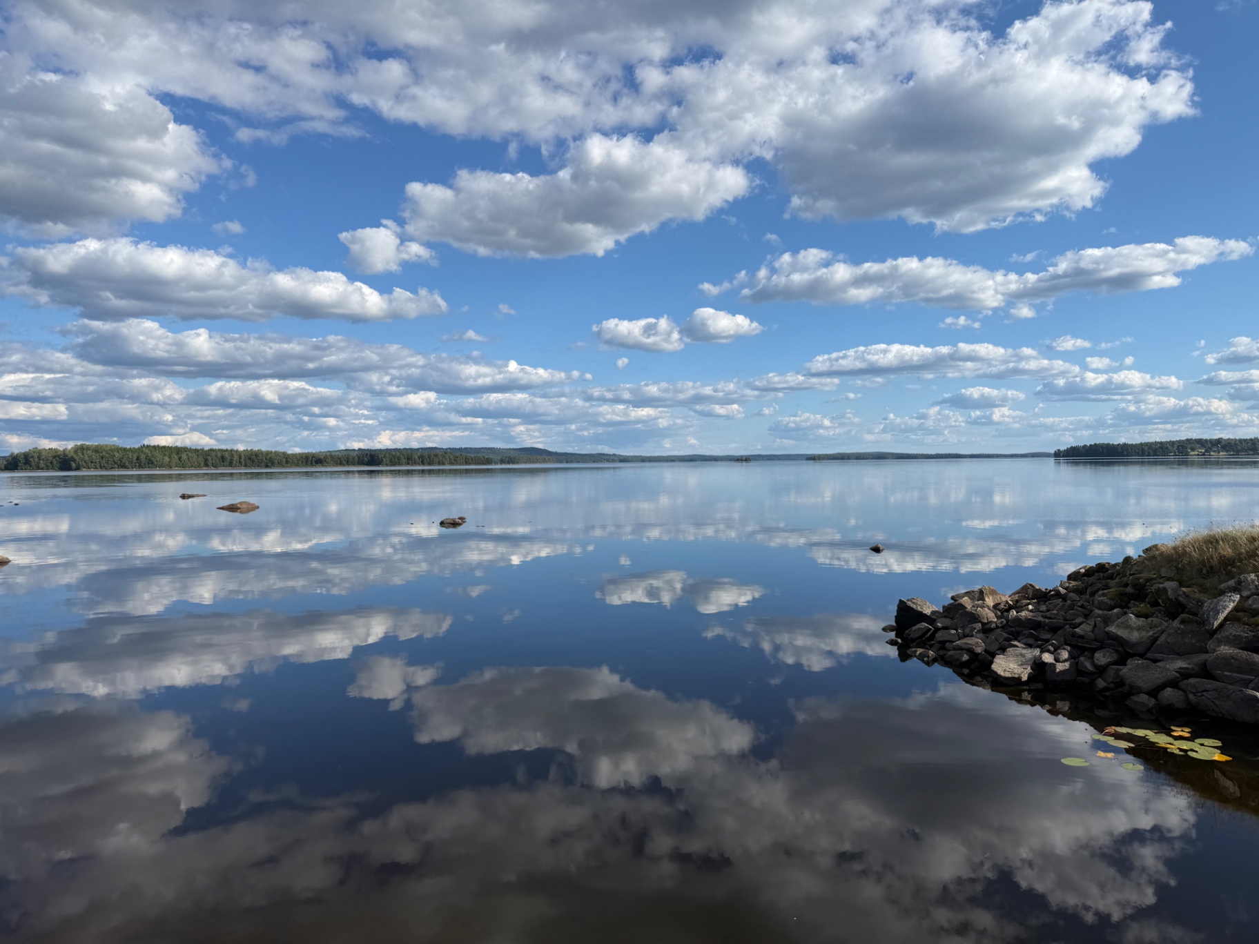 Sjön Rusken med spegelblankt vatten och moln
